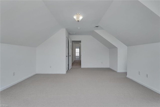 additional living space with light carpet and vaulted ceiling