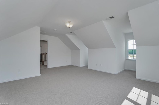 additional living space featuring lofted ceiling and light colored carpet