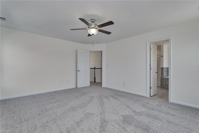 unfurnished bedroom featuring connected bathroom, light colored carpet, and ceiling fan