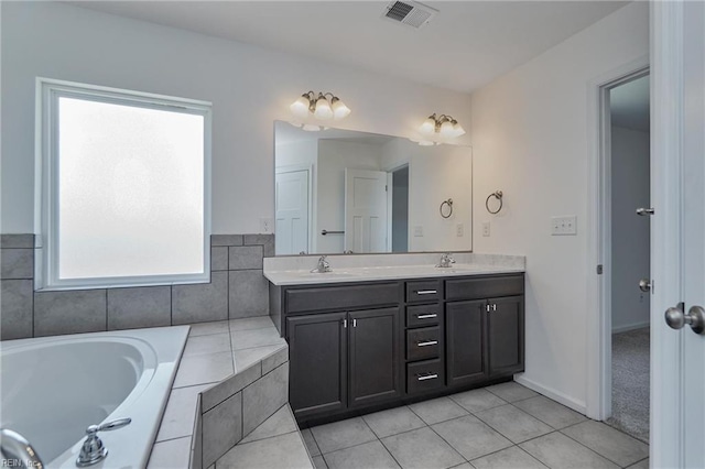 bathroom with vanity, tiled tub, and tile patterned floors