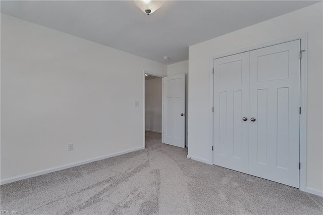 unfurnished bedroom with light carpet and a closet