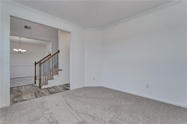 carpeted empty room featuring crown molding and an inviting chandelier