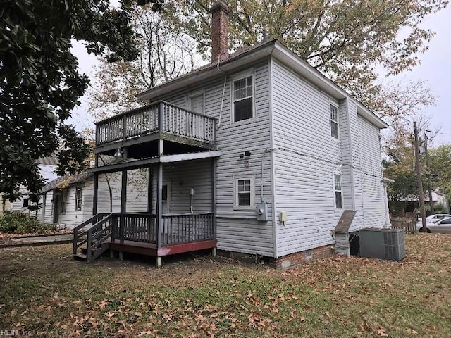 rear view of property with a wooden deck, central AC, and a lawn