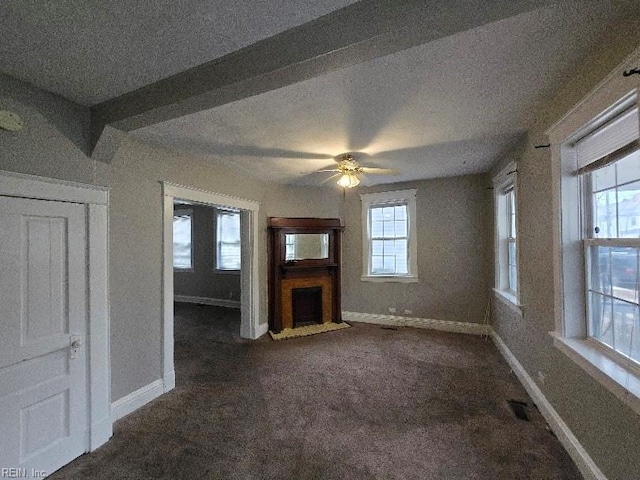 unfurnished living room with ceiling fan and dark colored carpet