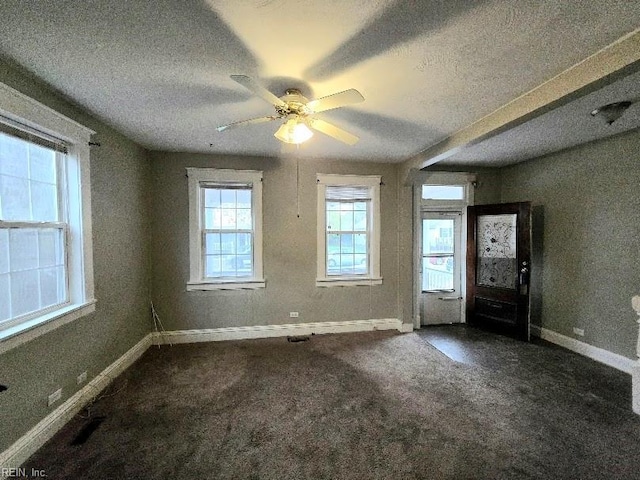 entrance foyer with dark colored carpet, ceiling fan, and a textured ceiling