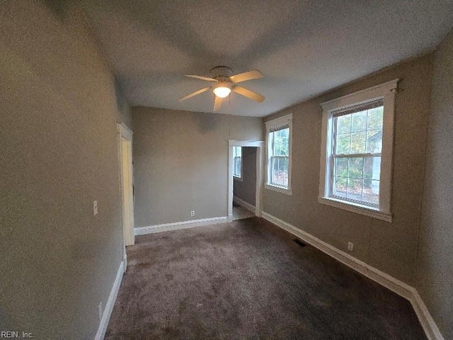 empty room featuring dark carpet and ceiling fan