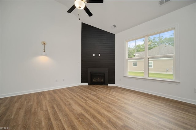 unfurnished living room featuring vaulted ceiling, wood-type flooring, a large fireplace, and ceiling fan