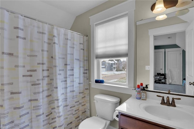 bathroom with walk in shower, plenty of natural light, toilet, and vanity