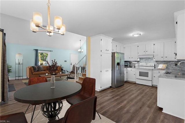 dining room with dark hardwood / wood-style flooring, lofted ceiling, sink, and a chandelier