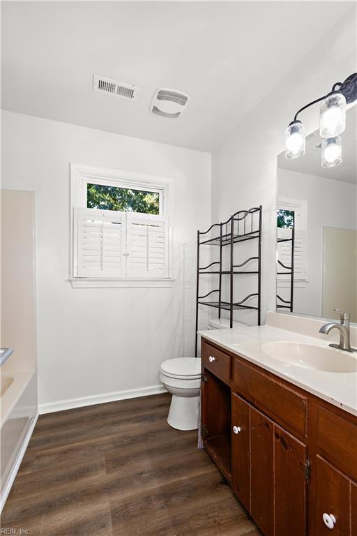 bathroom featuring vanity, wood-type flooring, and toilet