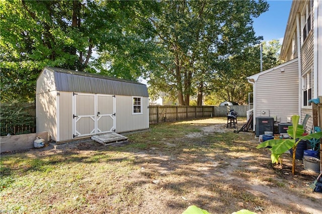 view of yard featuring central AC and a storage unit