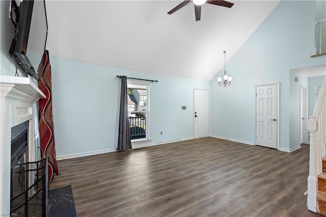 unfurnished living room featuring dark hardwood / wood-style flooring, ceiling fan with notable chandelier, and high vaulted ceiling