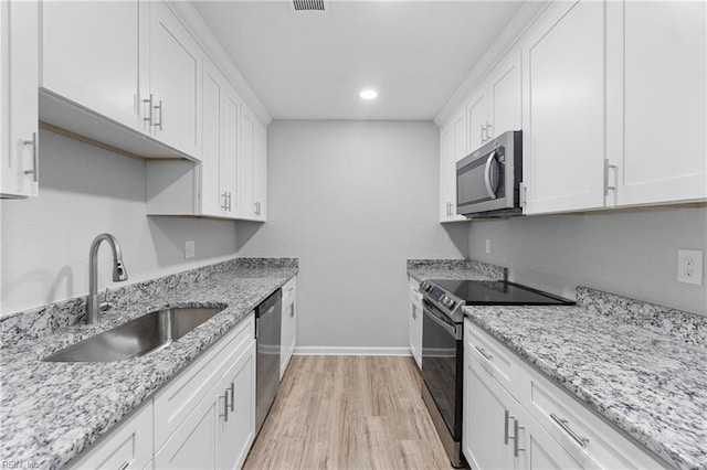 kitchen featuring white cabinetry, appliances with stainless steel finishes, sink, and light wood-type flooring