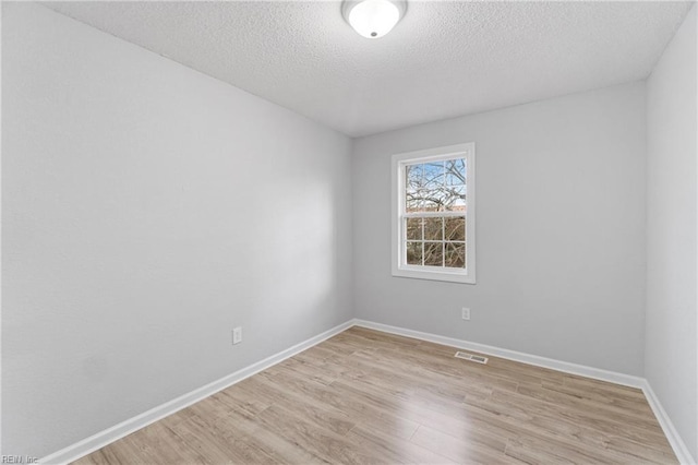 empty room featuring light hardwood / wood-style floors and a textured ceiling