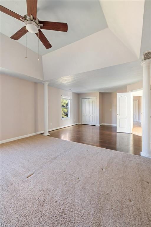 spare room with dark carpet, ceiling fan, and ornate columns