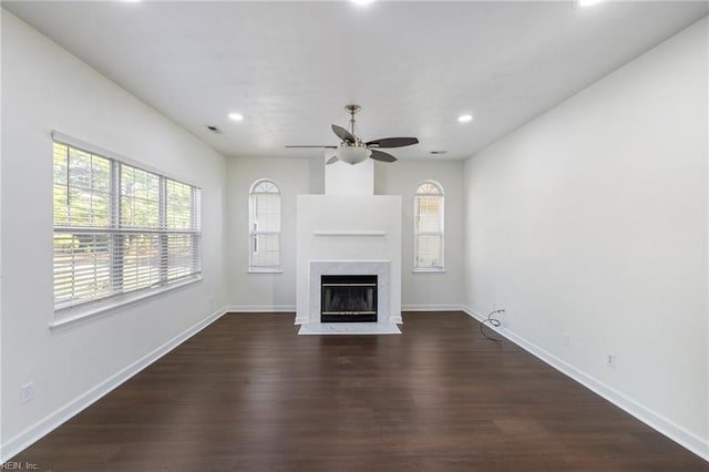 unfurnished living room featuring ceiling fan, a fireplace, and dark hardwood / wood-style flooring