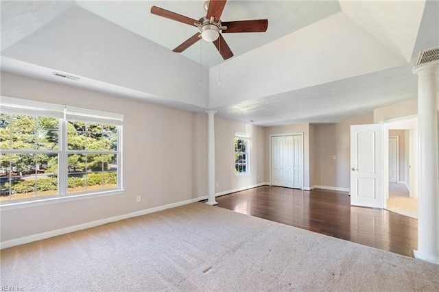 spare room with ceiling fan, lofted ceiling, decorative columns, and dark colored carpet