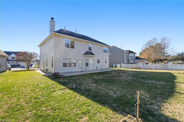 back of property with a patio area and a lawn