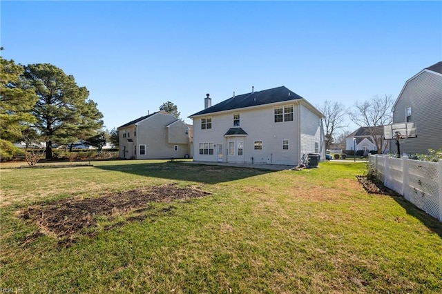 back of house featuring central AC and a lawn