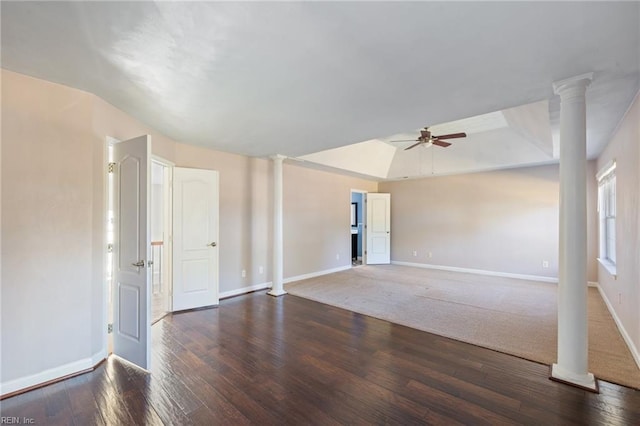 spare room with decorative columns, dark wood-type flooring, and ceiling fan