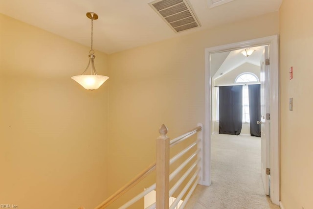 hall featuring vaulted ceiling and light colored carpet