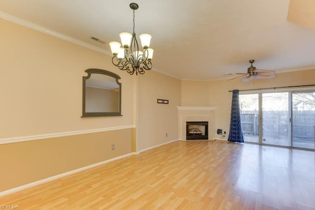 unfurnished living room with crown molding, ceiling fan with notable chandelier, and hardwood / wood-style flooring