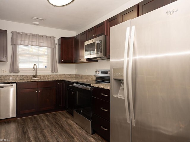 kitchen featuring stainless steel appliances, dark hardwood / wood-style flooring, sink, and light stone counters