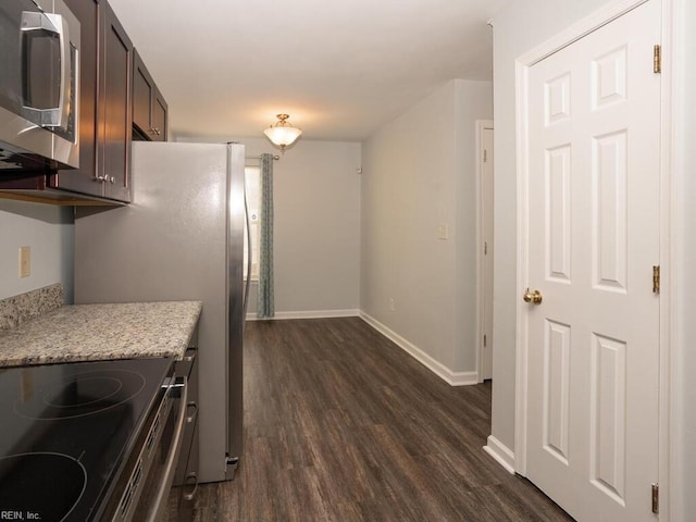 kitchen featuring light stone counters, dark brown cabinetry, dark wood-type flooring, and range with electric stovetop