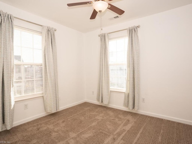 carpeted spare room with ceiling fan and a healthy amount of sunlight