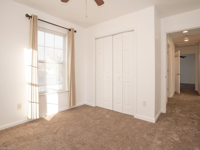 unfurnished bedroom with a closet, ceiling fan, and carpet