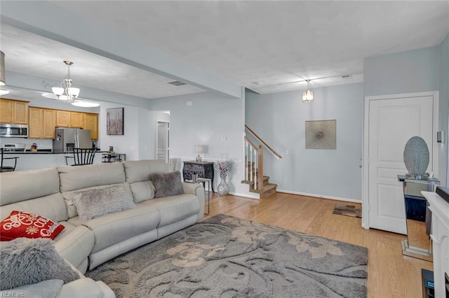 living room featuring a notable chandelier and light hardwood / wood-style floors