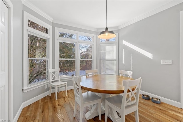 dining space featuring crown molding and light hardwood / wood-style floors