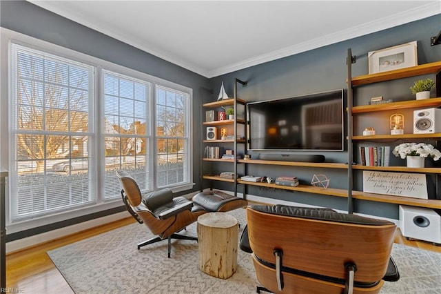 sitting room with crown molding, plenty of natural light, and light wood-type flooring