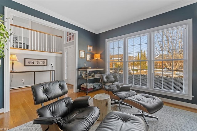 sitting room with ornamental molding and light wood-type flooring