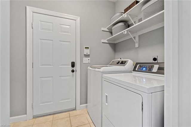 washroom with washing machine and clothes dryer and light tile patterned floors