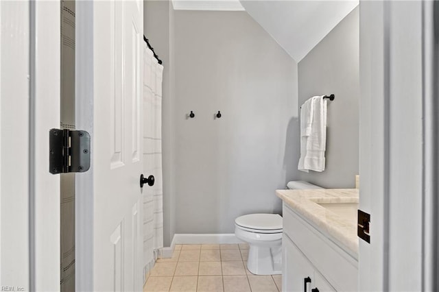 bathroom featuring tile patterned floors, vanity, toilet, and vaulted ceiling