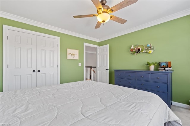 carpeted bedroom featuring ornamental molding, ceiling fan, and a closet