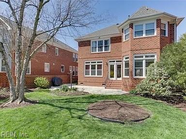 rear view of house featuring a patio and a lawn