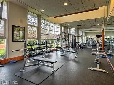 exercise room with a paneled ceiling and plenty of natural light