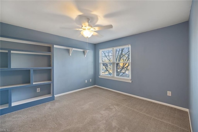 carpeted empty room with built in shelves and ceiling fan