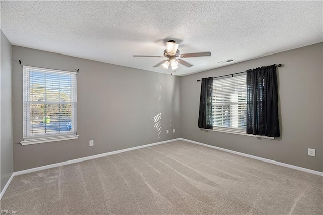 carpeted spare room with ceiling fan and a textured ceiling