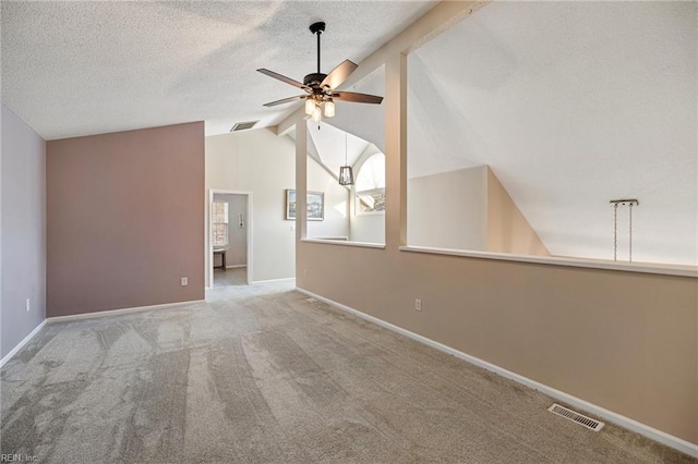 carpeted empty room featuring vaulted ceiling with beams, a textured ceiling, and ceiling fan