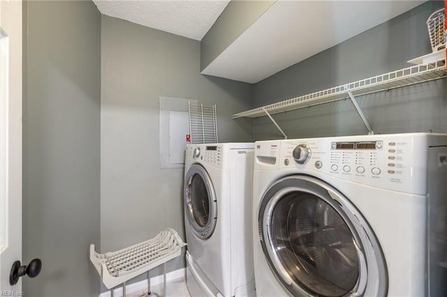 laundry room with a textured ceiling and washer and clothes dryer