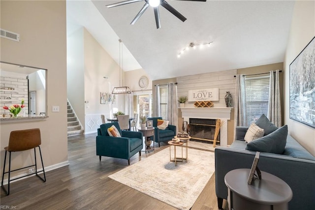 living room featuring dark hardwood / wood-style floors, vaulted ceiling, a large fireplace, and a healthy amount of sunlight