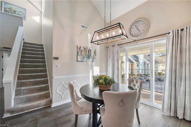 dining area featuring vaulted ceiling and dark hardwood / wood-style flooring