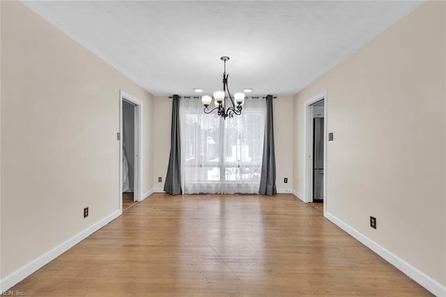 unfurnished dining area featuring a chandelier and light hardwood / wood-style floors