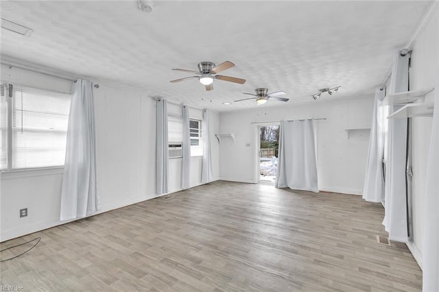 unfurnished living room with ceiling fan, light hardwood / wood-style floors, and a textured ceiling