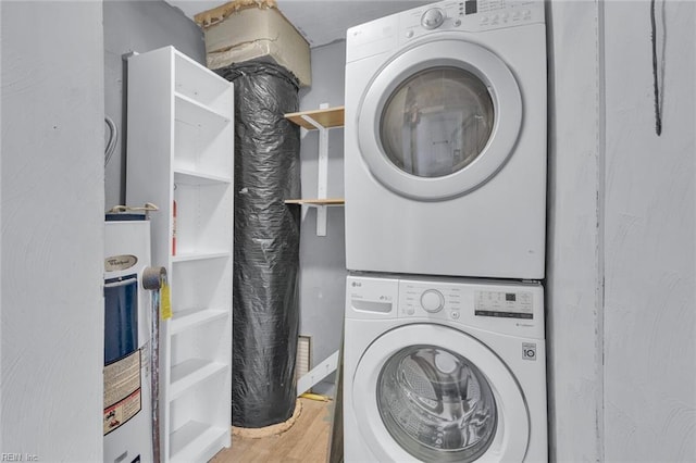 laundry room featuring stacked washer and dryer and wood-type flooring