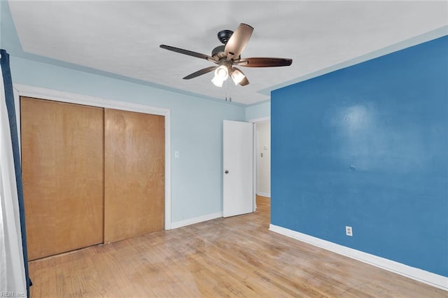 unfurnished bedroom with ceiling fan, a closet, and light wood-type flooring