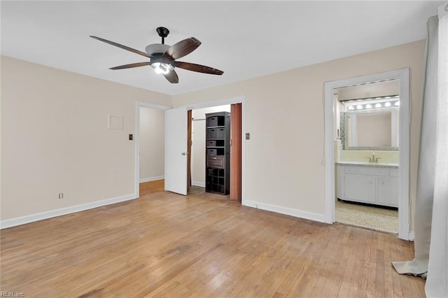 unfurnished bedroom with sink, ensuite bath, a closet, ceiling fan, and light hardwood / wood-style floors